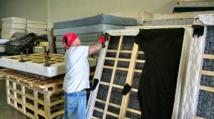 A Spring Back Utah employee disassembles a mattress inside the company's warehouse.